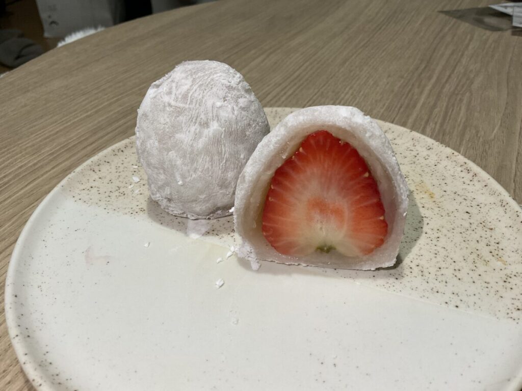 半分にカットされたいちご大福の断面。真っ赤な苺が白あんと餅に包まれているのがはっきり見える。