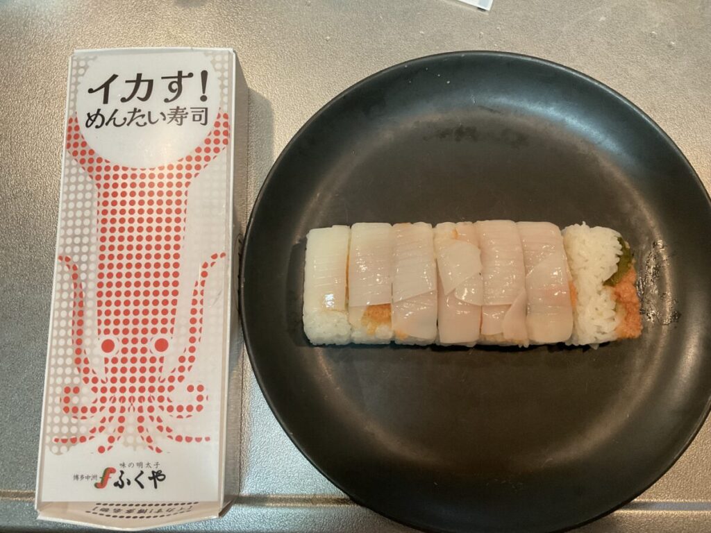パッケージの箱と実物の寿司を並べて、サイズ感や見た目を比較した様子。
